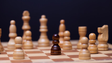 Chess, a lot of chess pieces on the Board. The white pieces surrounded the black pawn.
