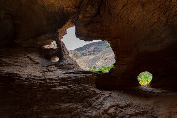 natural cave made by the erosion of wind and water naturally with small holes and windows towards the main road of the town