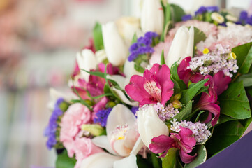 Delicate multi-colored bouquet with orchids and lavender. Flower business. Selective focus.