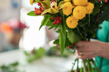 The work of the florist. Flower packaging. Creating a flower bouquet. Roses in a package. Selective focus.