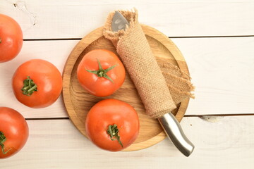 Fresh ripe, juicy, organic tomato, close-up, on a white painted, wooden table.