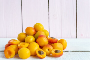 Fresh apricots lie in a pile on a wooden background. Fresh crop
