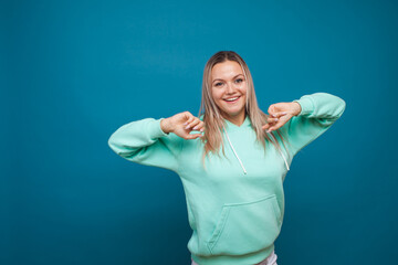 Cheerful hipster girl in hoodie and sunglasses.