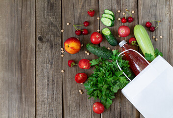 Fototapeta na wymiar Grocery shopping and balanced diet concept. Clean vegetables, berries and fruits with eco paper bag on rustic wooden background top view