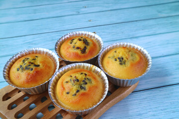 Fresh Baked Homemade Passion Fruit Muffins in Molds on Wooden Breadboard 