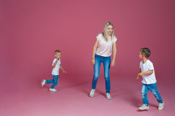 Fototapeta premium Beautiful blonde mom with two happy sons. Young woman and two baby boys,