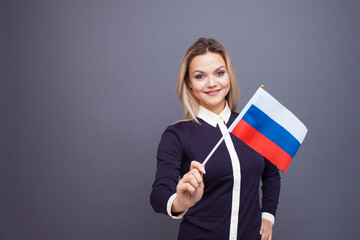 Immigration and the study of foreign languages, concept. A young smiling woman with a Russia flag...