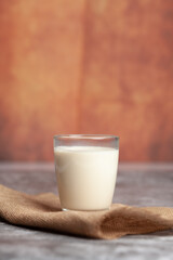 Picture of clear glass with milk, white, arranged in bright light
