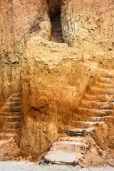 Staircase, carved in clay crag. Steep climb up srairs carved in cliff of loamy soil.