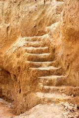 Staircase, carved in clay crag. Steep climb up srairs carved in cliff of loamy soil.