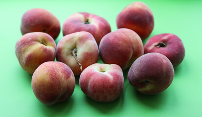 ripe juicy peaches on a green background close up