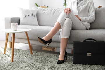 Businesswoman relaxing on sofa after work at home