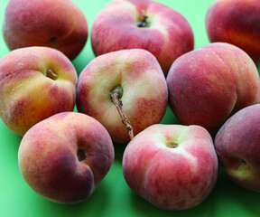 ripe juicy peaches on a green background close up
