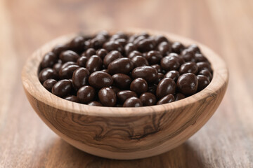 Chocolate drage with pine nuts in olive wood bowl