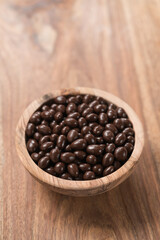 Chocolate drage with pine nuts in olive wood bowl