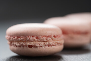 Tender pink color macarons on slate background closeup