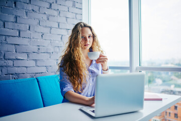 Thoughtful female student updating antivirus on modern laptop computer 