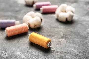 Cotton flowers and threads on dark background