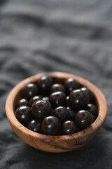 Chocolate drage with hazelnuts nuts in olive wood bowl
