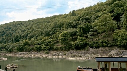A ferryboat arrives at the shore of Arashiyama and Katsura River in Kyoto Prefecture on May 30, 2020.