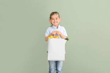 Little girl with food in bag on color background