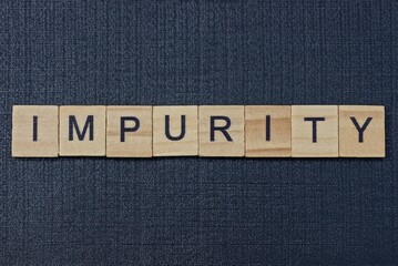 text on word impurity from gray wooden letters on a black background