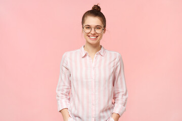 Portrait of young happy smiling teenage girl wearing striped shirt and round eyeglasses, holding...