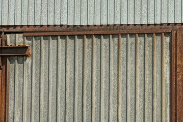 gray metal texture from an old iron wall with a rusty brown frame