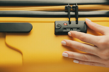 Woman opening lock on suitcase, closeup © Pixel-Shot