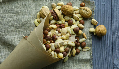 Mix of different nuts in a paper cup against the background