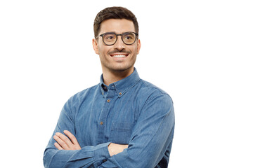 Young businessman wearing blue shirt and glasses, standing with arms crossed, looking away with dreamful smile, isolated on gray background