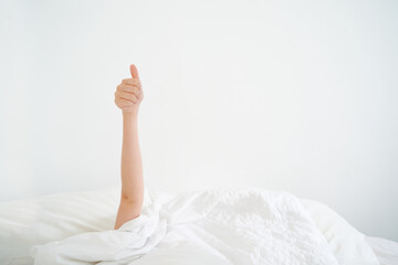woman Hand in bed showing of approval . Minimal happy morning concept.