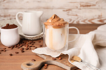 Glass cup of tasty dalgona coffee on table