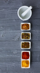 Various spices in a bowls on gray background
