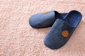 Pair of soft slippers on carpet