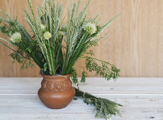 Bouquet of ears of grass and onion flowers on a wooden background.Village background.