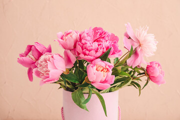 Beautiful peony flowers in vase on color background