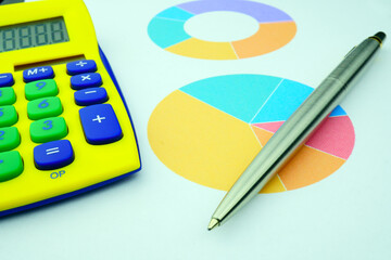 A yellow calculator is next to the chart and a metal ballpoint pen. Financial results. Report. Business model.