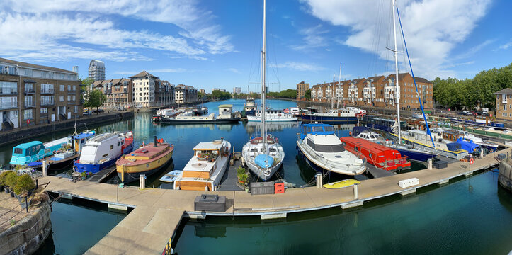 Panorama of Dockland Heritage in a sunny day with traditional boats and sailboats on the coast of Thames river in London