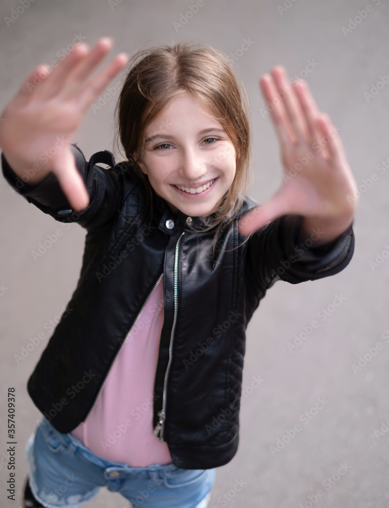 Poster Young girl showing frame with her hands outdoors, view from above