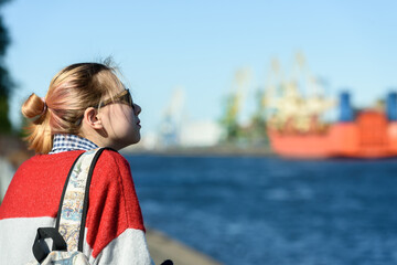 A girl alone in a commercial seaport on a walk
