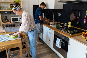A couple cooking Italian food.