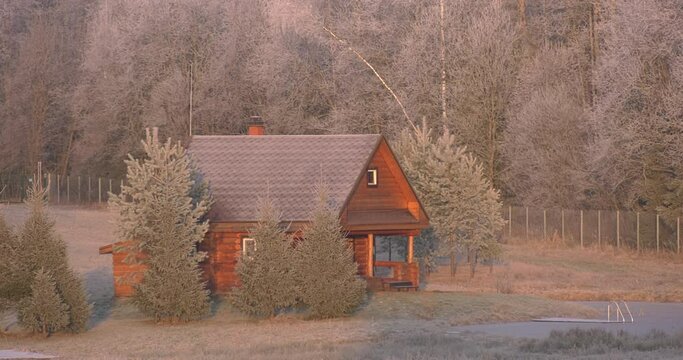 A house on the edge of the forest next to the freeze pond. Surrounded by frosted trees in complete silence of the estate.