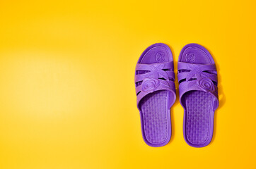 Violet slippers on a yellow background, top view, minimalist trend