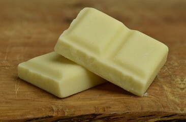Nutrition, diet and junk food. White chocolate bar pieces closeup.