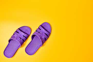 Violet slippers on a yellow background, top view, minimalist trend