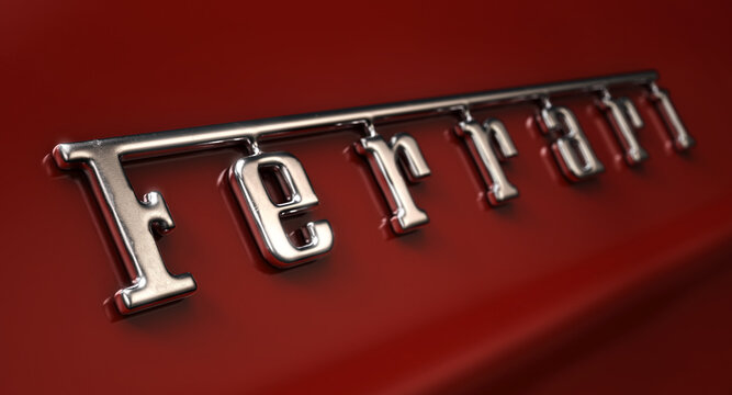 A closeup of a classic vintage ferrari chrome decal emblem on a car with a red paint job, 13 June 2020 in Bristol, United Kingdom