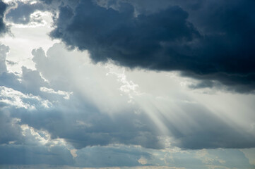 Fototapeta na wymiar Sunlight shining through black clouds