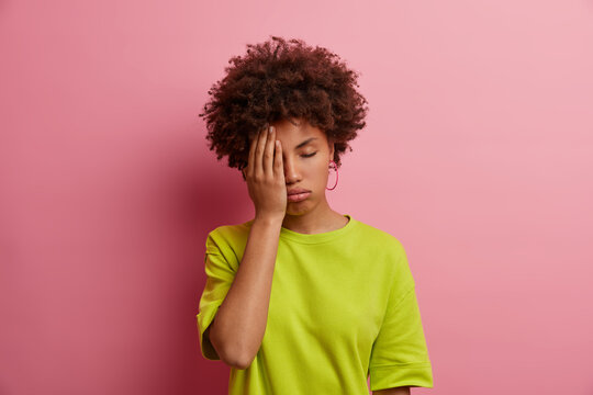 Portrait Of Depressed Bored Exhausted Woman Makes Face Palm, Has Indifferent Dull Expression, Tired Of Boring Story, Sighs From Tiredness, Fatigue Of Everything, Dressed In Casual Outfit, Poses Indoor