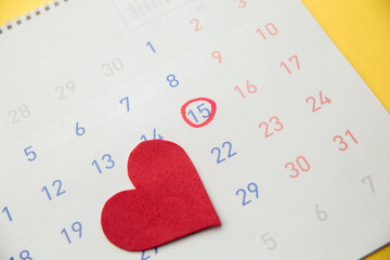 Red heart with red highlighter with ovulation day mark on calendar. Gynecology concept.